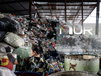 Burmese workers are sorting rotting food waste, fabric, and recyclable plastic by hand at a sorting facility in Bangkok, Thailand, on July 2...