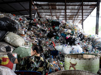 Burmese workers are sorting rotting food waste, fabric, and recyclable plastic by hand at a sorting facility in Bangkok, Thailand, on July 2...