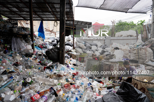 Burmese workers are sorting rotting food waste, fabric, and recyclable plastic by hand at a sorting facility in Bangkok, Thailand, on July 2...