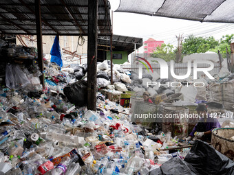 Burmese workers are sorting rotting food waste, fabric, and recyclable plastic by hand at a sorting facility in Bangkok, Thailand, on July 2...