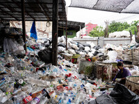 Burmese workers are sorting rotting food waste, fabric, and recyclable plastic by hand at a sorting facility in Bangkok, Thailand, on July 2...