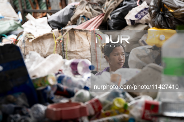 Burmese workers are sorting rotting food waste, fabric, and recyclable plastic by hand at a sorting facility in Bangkok, Thailand, on July 2...