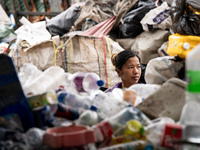 Burmese workers are sorting rotting food waste, fabric, and recyclable plastic by hand at a sorting facility in Bangkok, Thailand, on July 2...