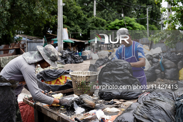 Burmese workers are sorting rotting food waste, fabric, and recyclable plastic by hand at a sorting facility in Bangkok, Thailand, on July 2...