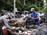 Burmese workers are sorting rotting food waste, fabric, and recyclable plastic by hand at a sorting facility in Bangkok, Thailand, on July 2...