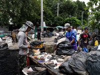 Burmese workers are sorting rotting food waste, fabric, and recyclable plastic by hand at a sorting facility in Bangkok, Thailand, on July 2...