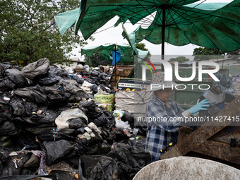 Burmese workers are sorting rotting food waste, fabric, and recyclable plastic by hand at a sorting facility in Bangkok, Thailand, on July 2...