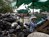 Burmese workers are sorting rotting food waste, fabric, and recyclable plastic by hand at a sorting facility in Bangkok, Thailand, on July 2...