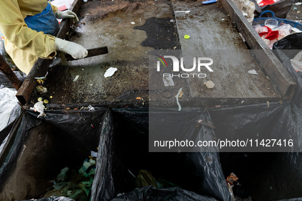 Burmese workers are sorting rotting food waste, fabric, and recyclable plastic by hand at a sorting facility in Bangkok, Thailand, on July 2...