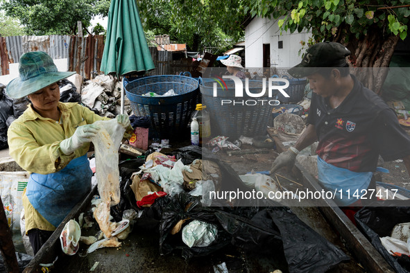 Burmese workers are sorting rotting food waste, fabric, and recyclable plastic by hand at a sorting facility in Bangkok, Thailand, on July 2...