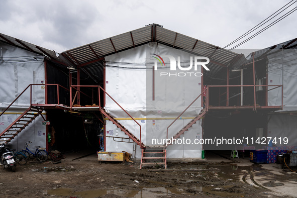 Corrugated steel housing units are accommodating Burmese workers who are sorting rotting food waste, fabric, and recyclable plastic by hand...