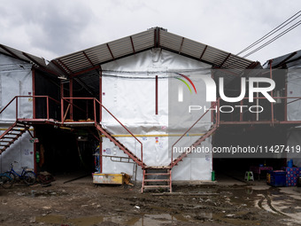 Corrugated steel housing units are accommodating Burmese workers who are sorting rotting food waste, fabric, and recyclable plastic by hand...