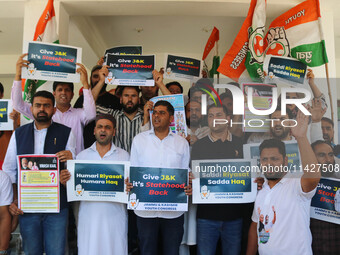 Members of the youth wing of the Indian National Congress party are shouting slogans and holding placards during a protest in Srinagar, Jamm...