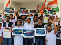 Members of the youth wing of the Indian National Congress party are shouting slogans and holding placards during a protest in Srinagar, Jamm...