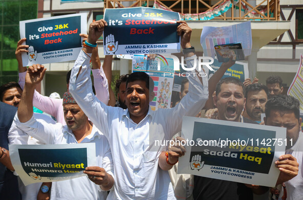 Members of the youth wing of the Indian National Congress party are shouting slogans and holding placards during a protest in Srinagar, Jamm...