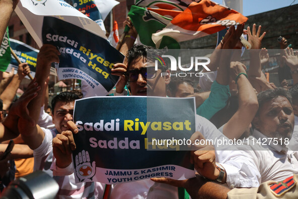 Members of the youth wing of the Indian National Congress party are shouting slogans and holding placards during a protest in Srinagar, Jamm...