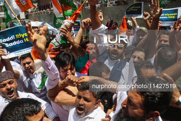 Members of the youth wing of the Indian National Congress party are shouting slogans and holding placards during a protest in Srinagar, Jamm...