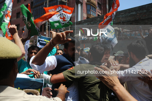 Members of the youth wing of the Indian National Congress party are shouting slogans as Indian police officers are trying to stop them durin...