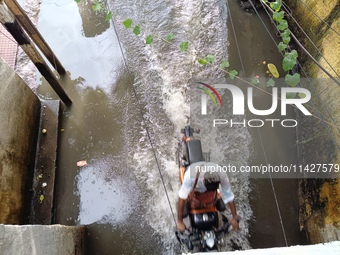 Commuters are wading through a waterlogged subway during the monsoon rain in Kolkata, India, on July 22, 2024. (