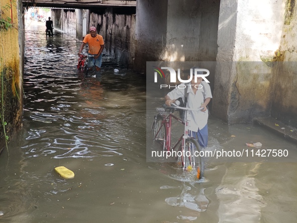 Commuters are wading through a waterlogged subway during the monsoon rain in Kolkata, India, on July 22, 2024. 