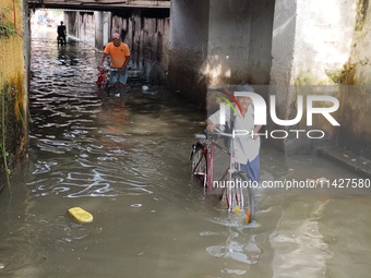 Commuters are wading through a waterlogged subway during the monsoon rain in Kolkata, India, on July 22, 2024. (