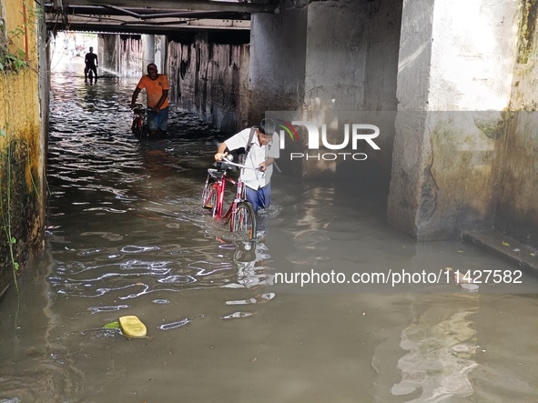 Commuters are wading through a waterlogged subway during the monsoon rain in Kolkata, India, on July 22, 2024. 