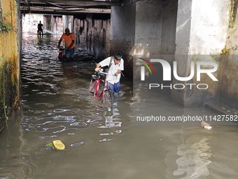 Commuters are wading through a waterlogged subway during the monsoon rain in Kolkata, India, on July 22, 2024. (