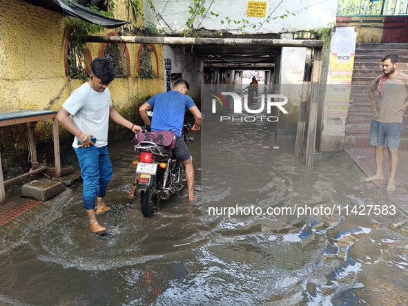 Commuters are wading through a waterlogged subway during the monsoon rain in Kolkata, India, on July 22, 2024. 