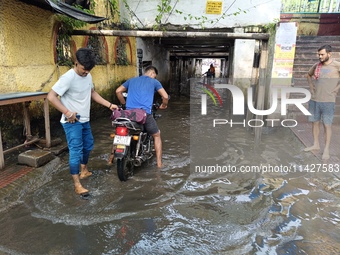 Commuters are wading through a waterlogged subway during the monsoon rain in Kolkata, India, on July 22, 2024. (