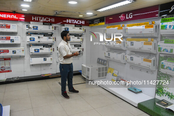 A man is operating an air conditioner at an electronic store in Kolkata, India, on July 22, 2024. The budget is boosting the ''Make in India...