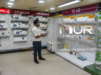 A man is operating an air conditioner at an electronic store in Kolkata, India, on July 22, 2024. The budget is boosting the ''Make in India...