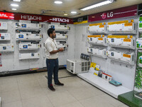 A man is operating an air conditioner at an electronic store in Kolkata, India, on July 22, 2024. The budget is boosting the ''Make in India...