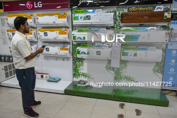 A man is operating an air conditioner at an electronic store in Kolkata, India, on July 22, 2024. The budget is boosting the ''Make in India...