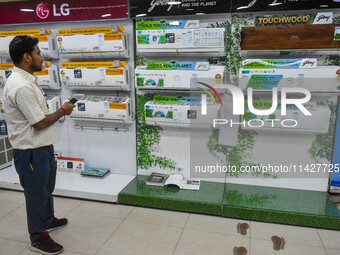 A man is operating an air conditioner at an electronic store in Kolkata, India, on July 22, 2024. The budget is boosting the ''Make in India...