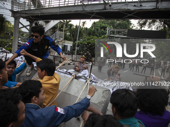 Students from various universities are trying to break through a barrier as they stage a demonstration to commemorate 10 years of Jokowi's g...