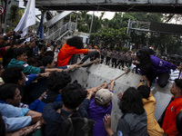 Students from various universities are trying to break through a barrier as they stage a demonstration to commemorate 10 years of Jokowi's g...