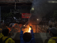 Students from various universities are trying to break through a barrier as they stage a demonstration to commemorate 10 years of Jokowi's g...