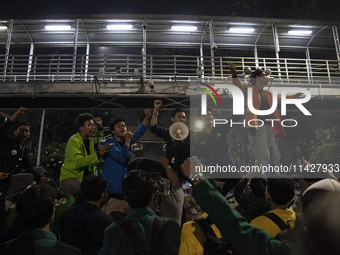 Students from various universities are trying to break through a barrier as they stage a demonstration to commemorate 10 years of Jokowi's g...