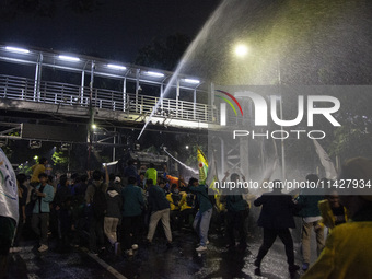 Police are firing water cannons to disperse the students as they are trying to break through the barrier during the demonstration to commemo...