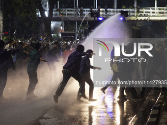 Police are firing water cannons to disperse the students as they are trying to break through the barrier during the demonstration to commemo...