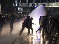 Police are firing water cannons to disperse the students as they are trying to break through the barrier during the demonstration to commemo...