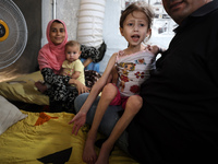 A doctor is holding Jana Ayad, a malnourished Palestinian girl, as she is receiving treatment at the International Medical Corps field hospi...