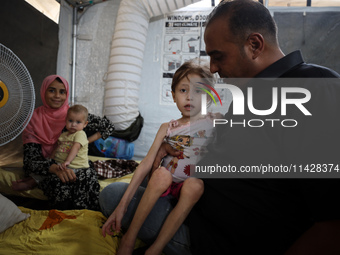 A doctor is holding Jana Ayad, a malnourished Palestinian girl, as she is receiving treatment at the International Medical Corps field hospi...