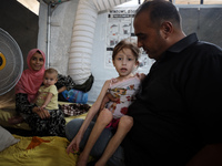 A doctor is holding Jana Ayad, a malnourished Palestinian girl, as she is receiving treatment at the International Medical Corps field hospi...