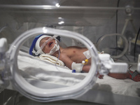 A Palestinian baby is lying in an incubator at the newborns' intensive care unit at the International Medical Corps field hospital, amid the...