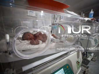 A Palestinian baby is lying in an incubator at the newborns' intensive care unit at the International Medical Corps field hospital, amid the...