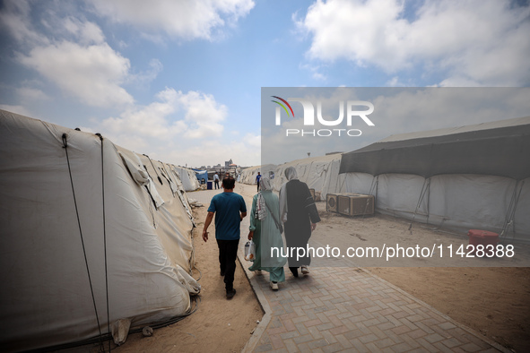 Palestinians are walking at the International Medical Corps field hospital, amid the Israel-Hamas conflict, in Deir Al-Balah in the southern...