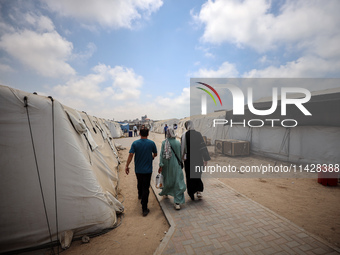 Palestinians are walking at the International Medical Corps field hospital, amid the Israel-Hamas conflict, in Deir Al-Balah in the southern...