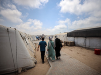 Palestinians are walking at the International Medical Corps field hospital, amid the Israel-Hamas conflict, in Deir Al-Balah in the southern...