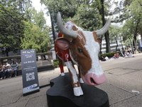 A fiberglass cow painting by an artist is being seen during the inauguration of the 'Cowparade Mexico 2024' on Avenida Reforma in Mexico Cit...